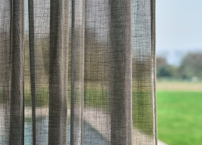 Eine Aufnahme von einem schallabsorbierenden Vorhang vor einem Fenster.