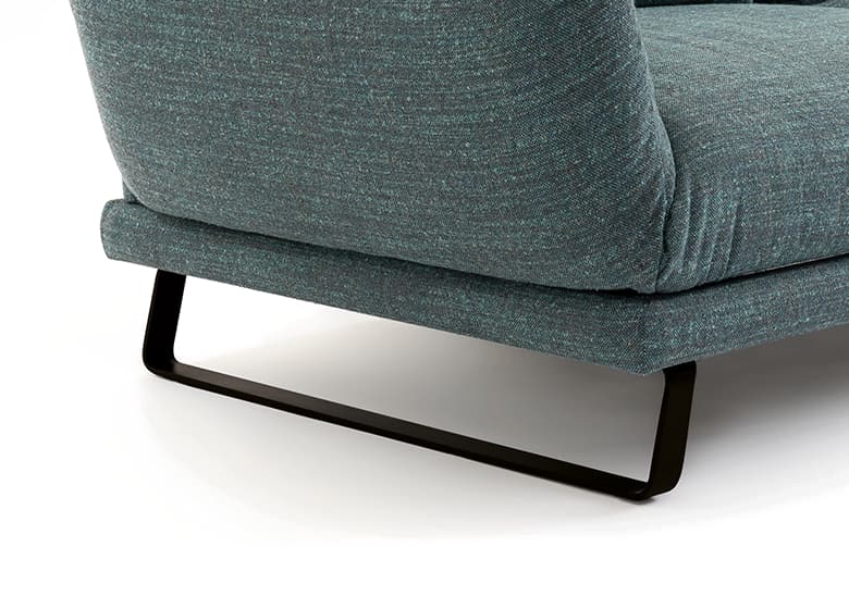 Nahaufnahme des Fußes eines grünen Sofas in schwarz.