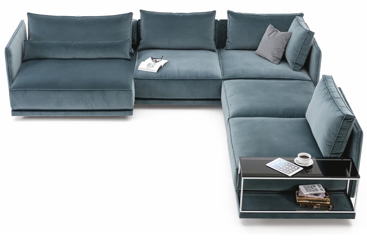 Freisteller eines blau/grauen Sofas mit einem Beistelltisch. Auf dem SOfa liegt ein graues Deko-Kissen.