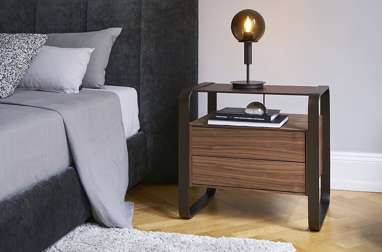 Beistelltisch aus Holz neben einem Bett