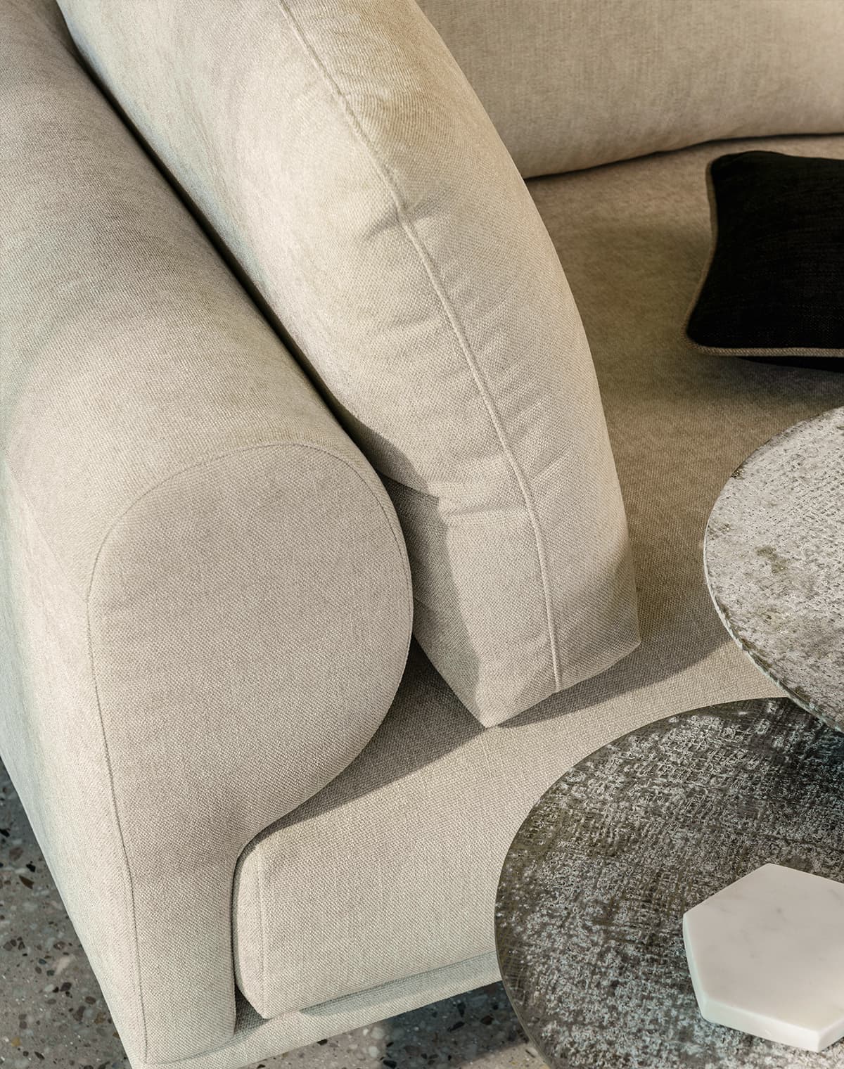 Beiges Sofa mit schwarzem Kissen und einem Beistelltisch