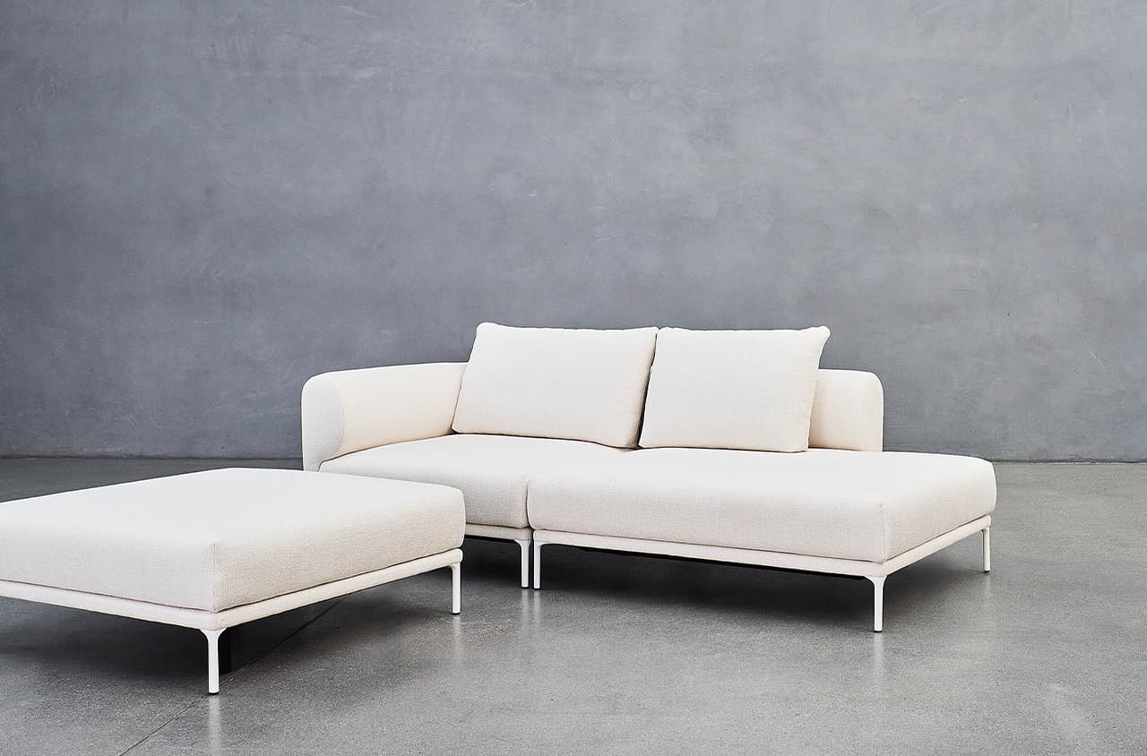 Sofa Loop in weiß auf grauem Boden und vor einer grauen Wand