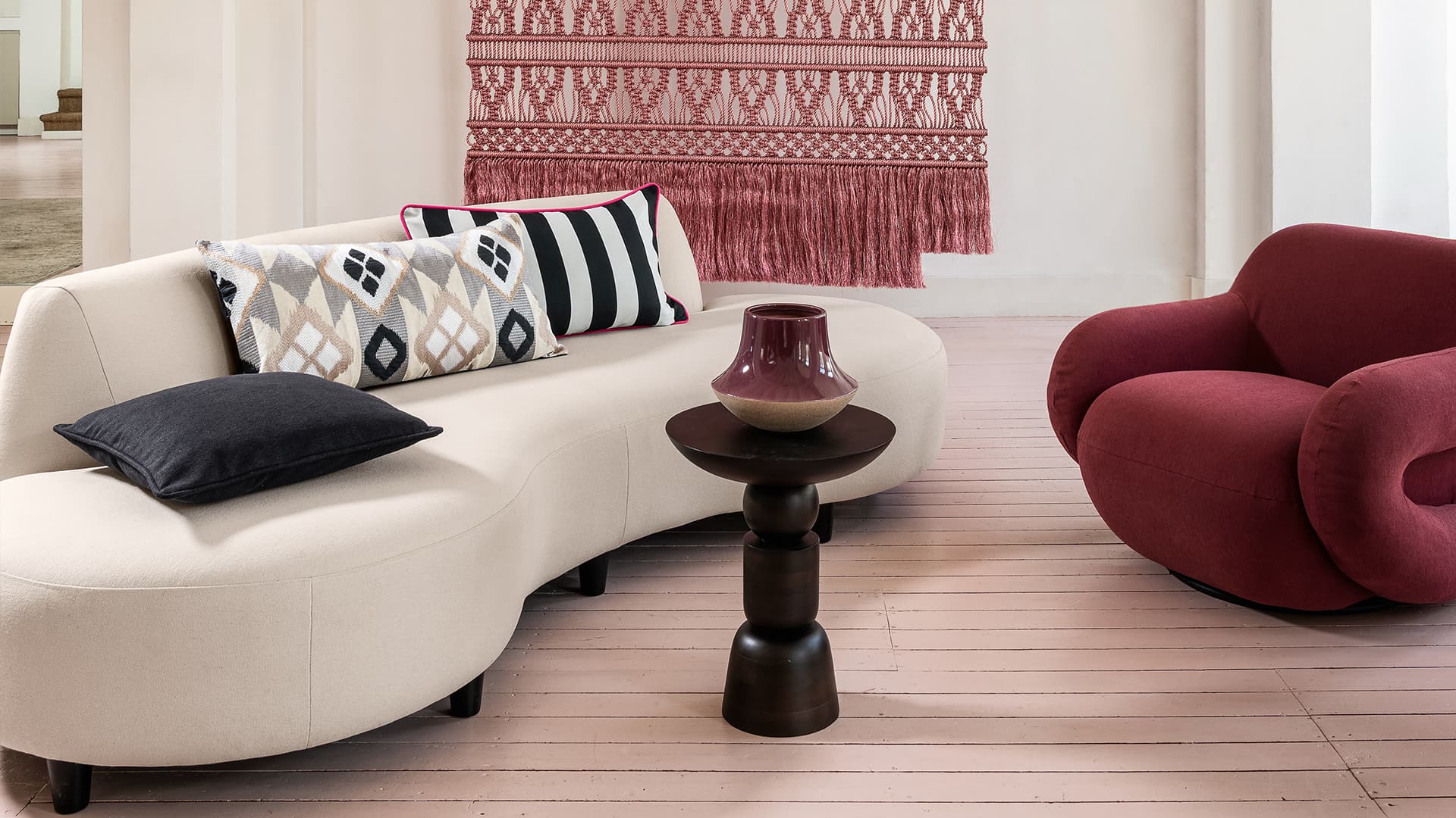 Ein weißes Sofa mit Kissen und ein roter Sessel.