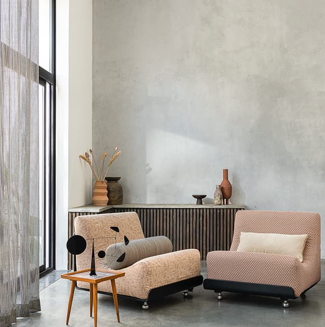 4 Sessel in rosa vor einer grauen Wand