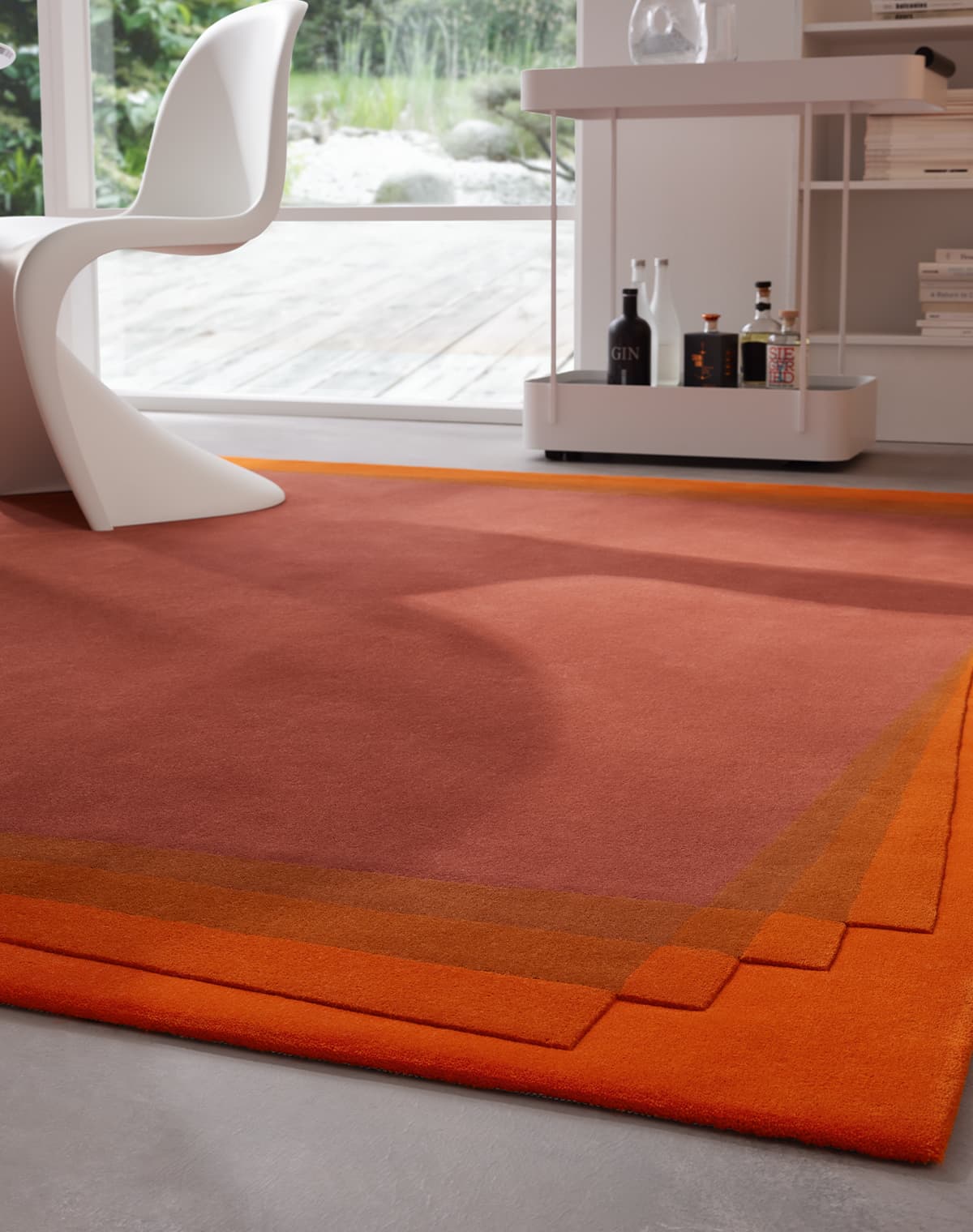 Teppich Contour Bliss in orange, von einer Teppich Ecke fotografiert, mit einem weißen Stuhl