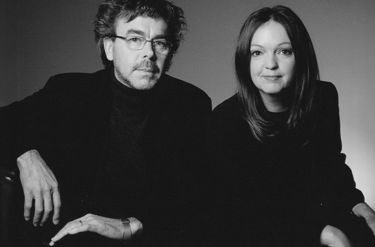 Portraitfoto von einem Mann und einer Frau die in die Kamera schauen.