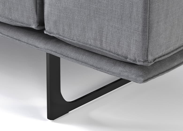 Nahaufnahme einer schwarzen, schmalen Kufe eines grauen SOfas