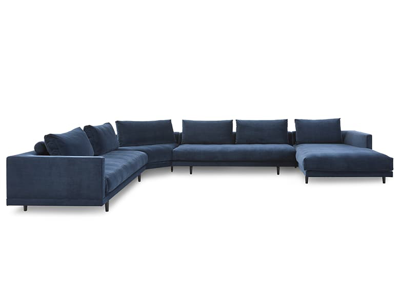 Freisteller eines blauen Sofas mit einem Eckteil und einem Longchair.