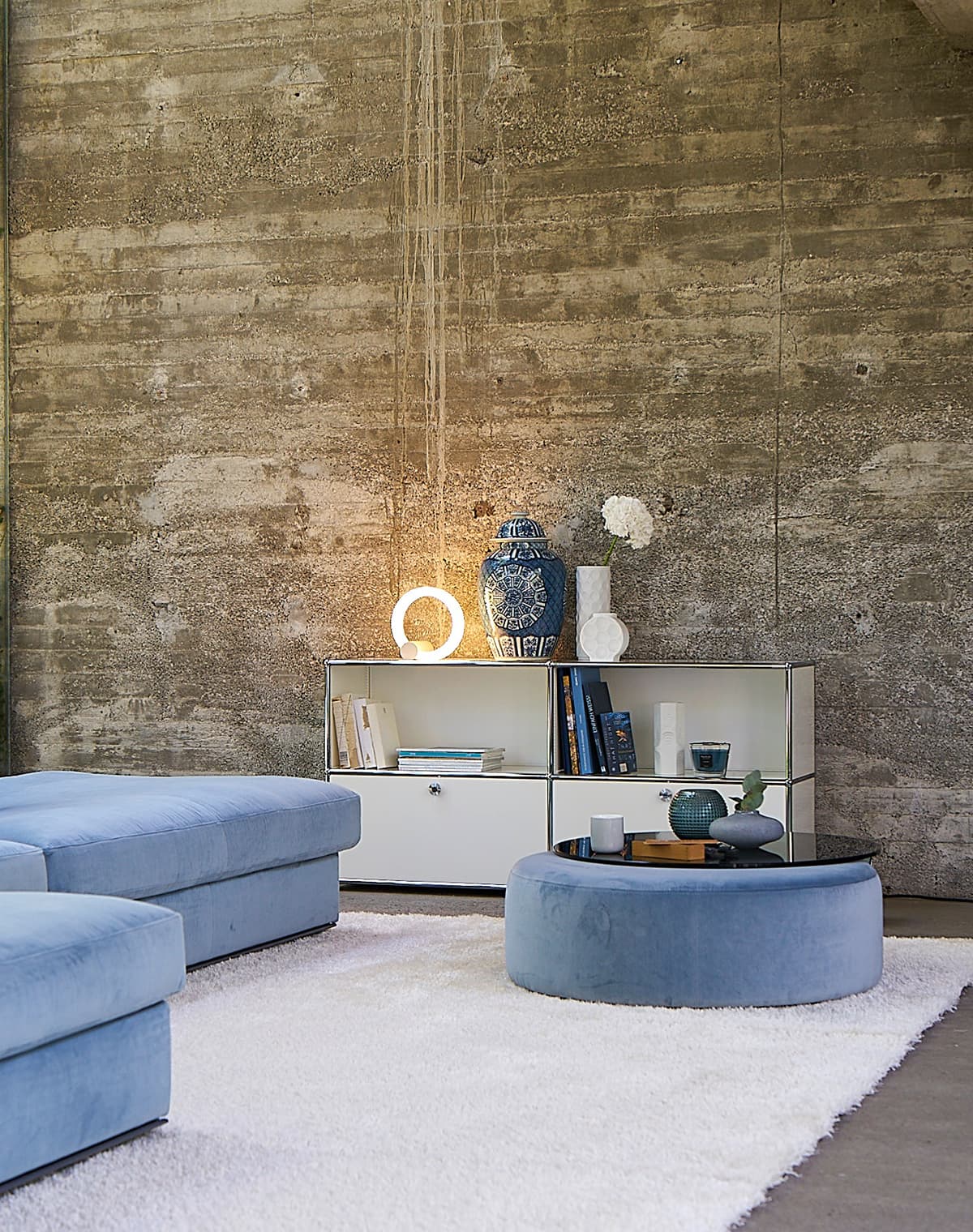 Couch- und Beistelltisch Luna in blau in einer Wohnsituation mit einem blauen Sofa und einem weißen Teppich