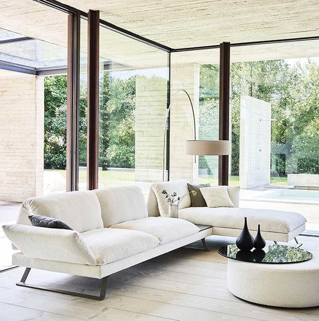 Weißes Sofa in einem hellen raum mit großen offenen Fenstern