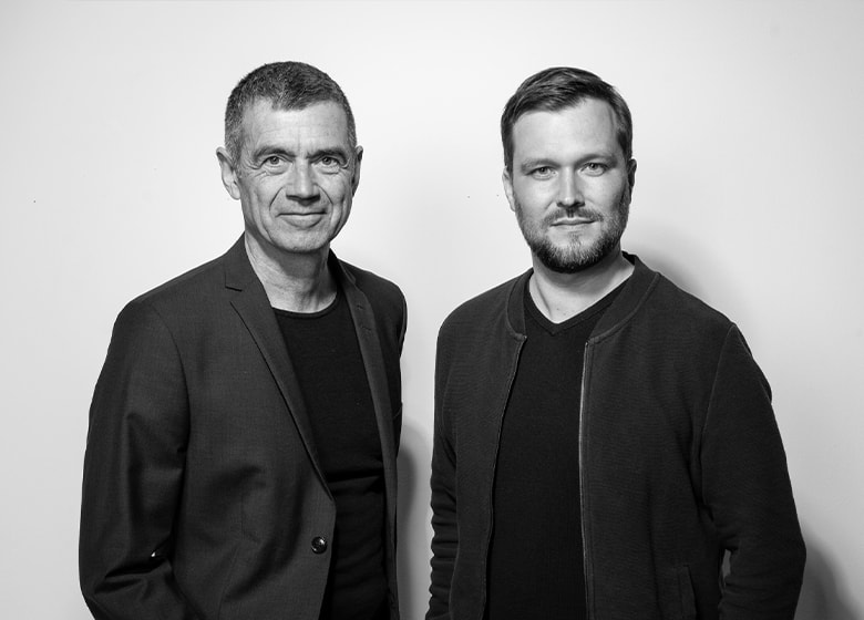 Portraitfotos von zwei Männern die freundlich in die Kamera schauen.