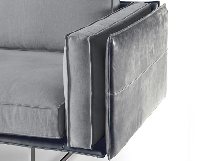 Freisteller einer Nahaufnahme einer Amrlehne mit Kissen eines grauen Sofas