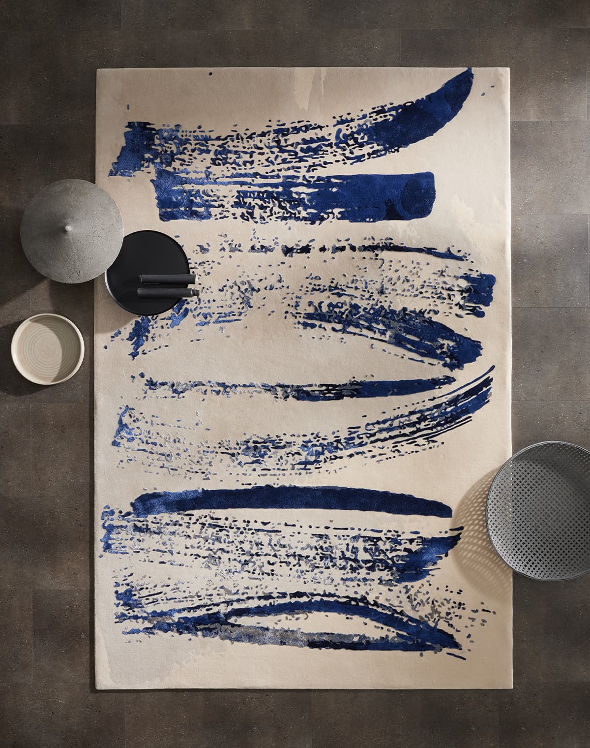 Teppich mit abstraktem Muster in Blau- und Grautönen auf hellem Grund. 