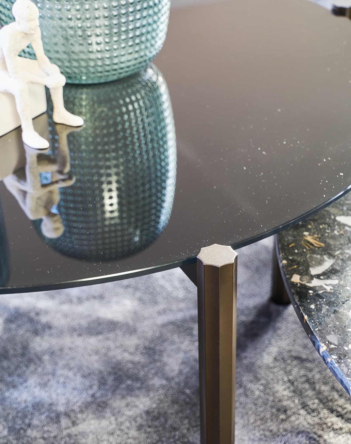 Detailaufnahme von dem Tisch Hamilton in schwarz, auf dem eine weiße Figur und eine blaue Vase stehen