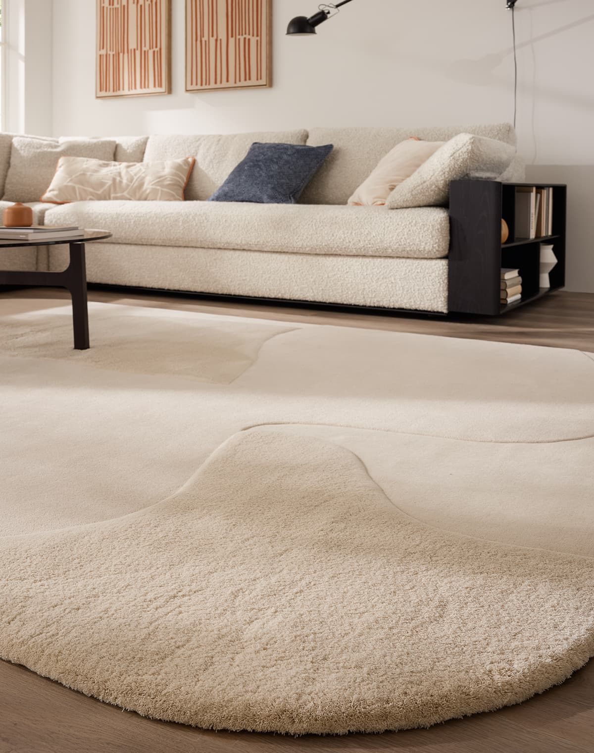 Teppich Arctic Harmony II in weiß in einer Raumsituation mit einem weißen Sofa und schwarzen Tisch von einer Teppichecke auf dem Boden nach oben fotografiert