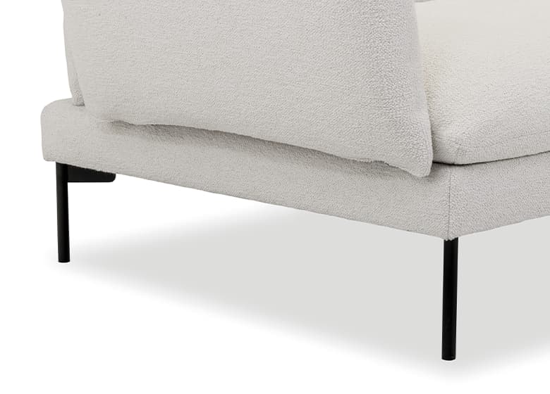 Nahaufnahme eines runden, schwarzen Metall-Fußes eines weißen Sofas.