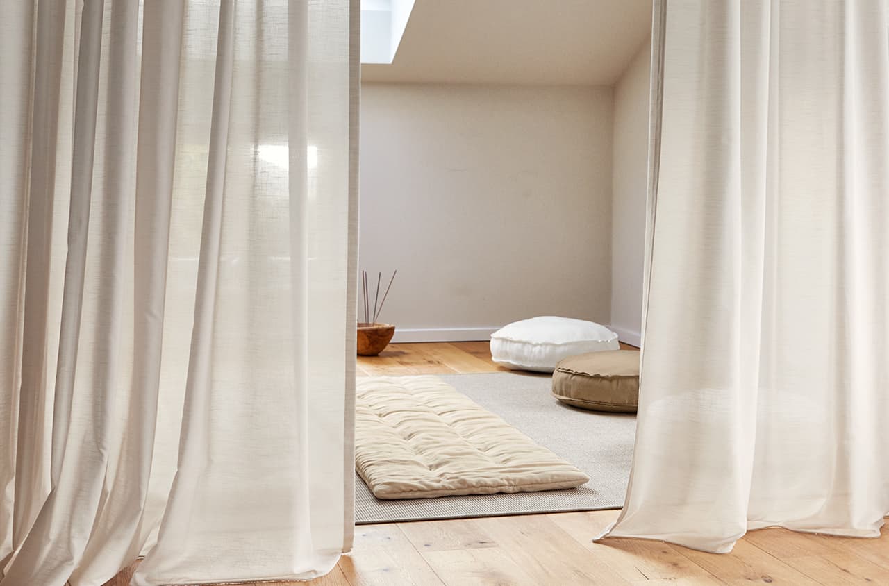 Weiße Gardinen und eine Massagematte in beige