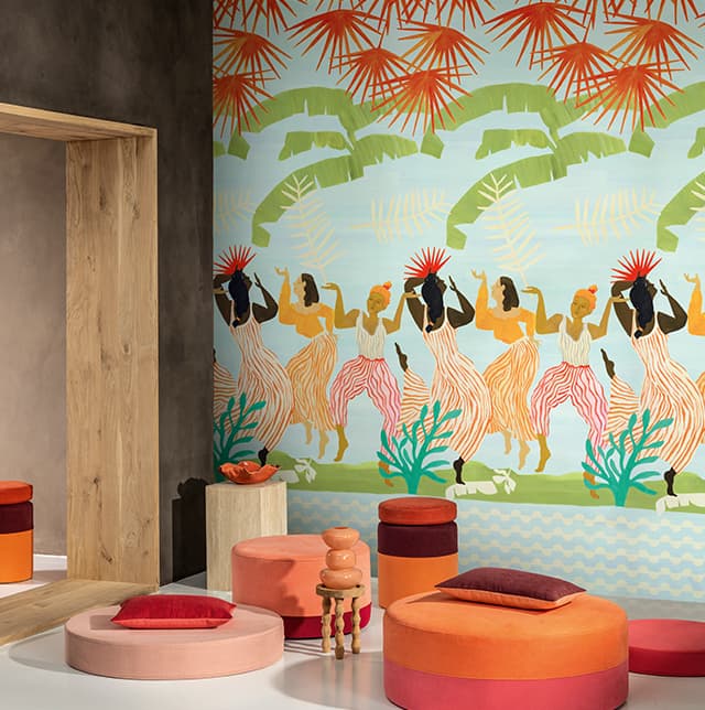 Poufs in rot, rosa und orange vor einer Tapete mit tanzenden Frauen