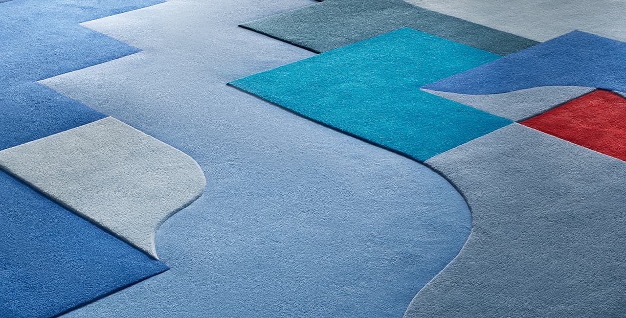 Teppichdesign in verschiedenen blauen Tönen mit etwas rot und gelb und verschiedenen geometrischen Formen