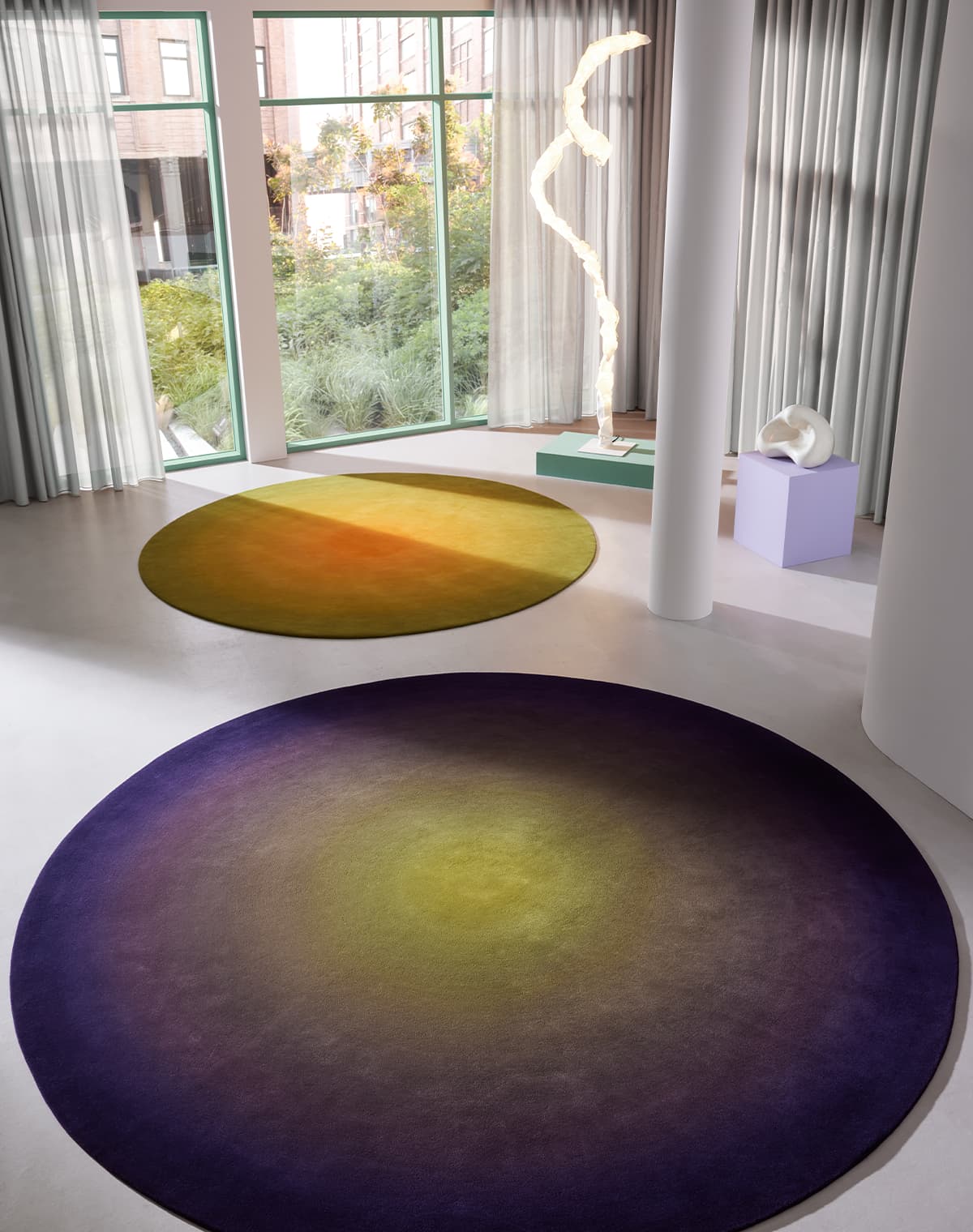 Teppich Aurora Sphere in zwei verschiedenen Farbkombinationen auf einem weißen Boden